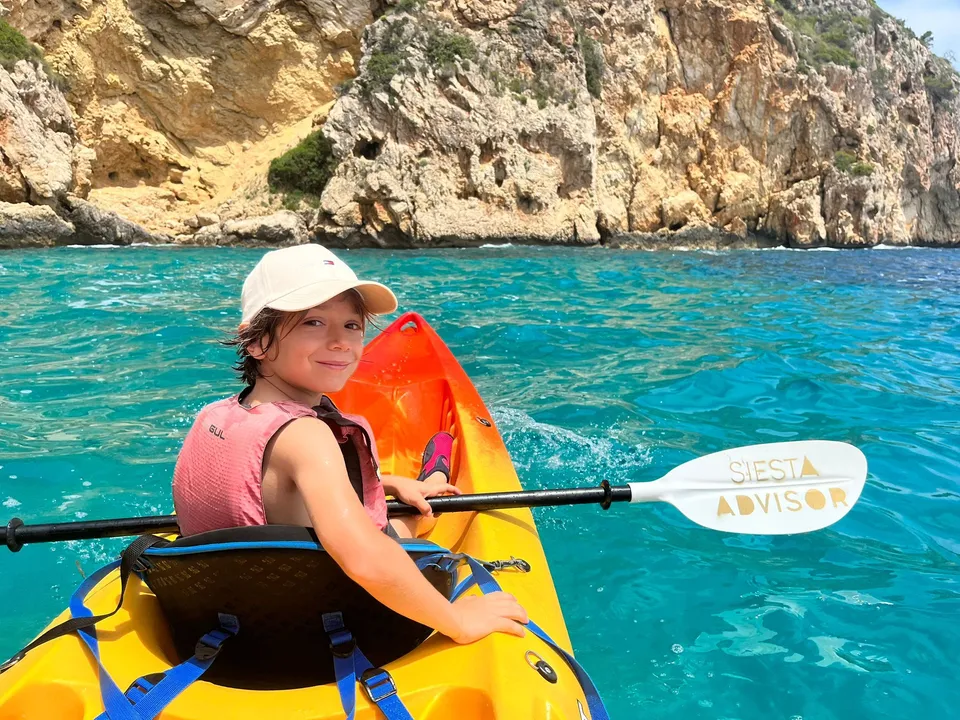 A Summer Camp girl paddling a Siesta Advisor kayak along the Jávea cliffs