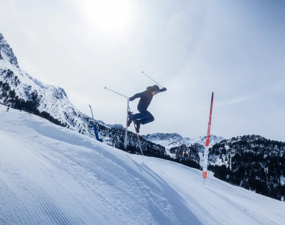 A Winter Camp skier jumping on the slopes of Grandvalira, Andorra
