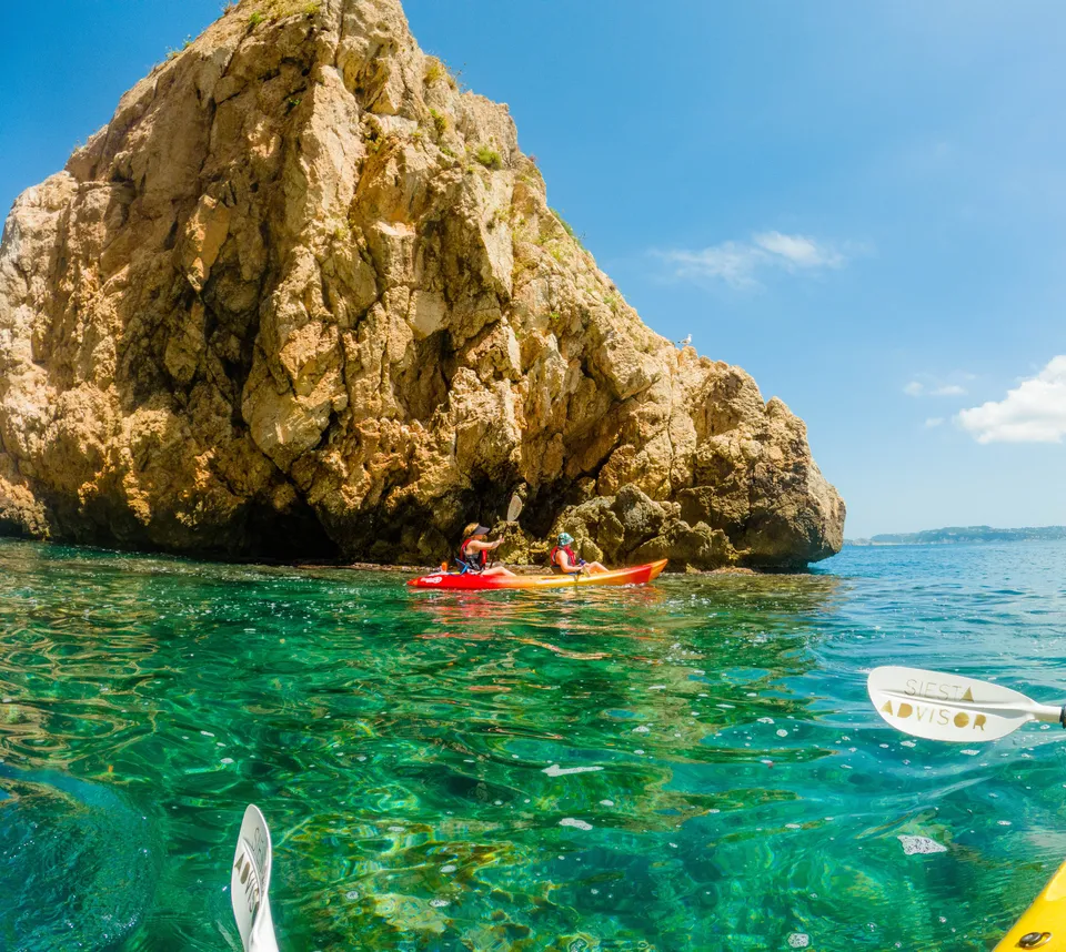 Kayaks beneath the natural arches of the Cova dels Arcs at Cala Moraig