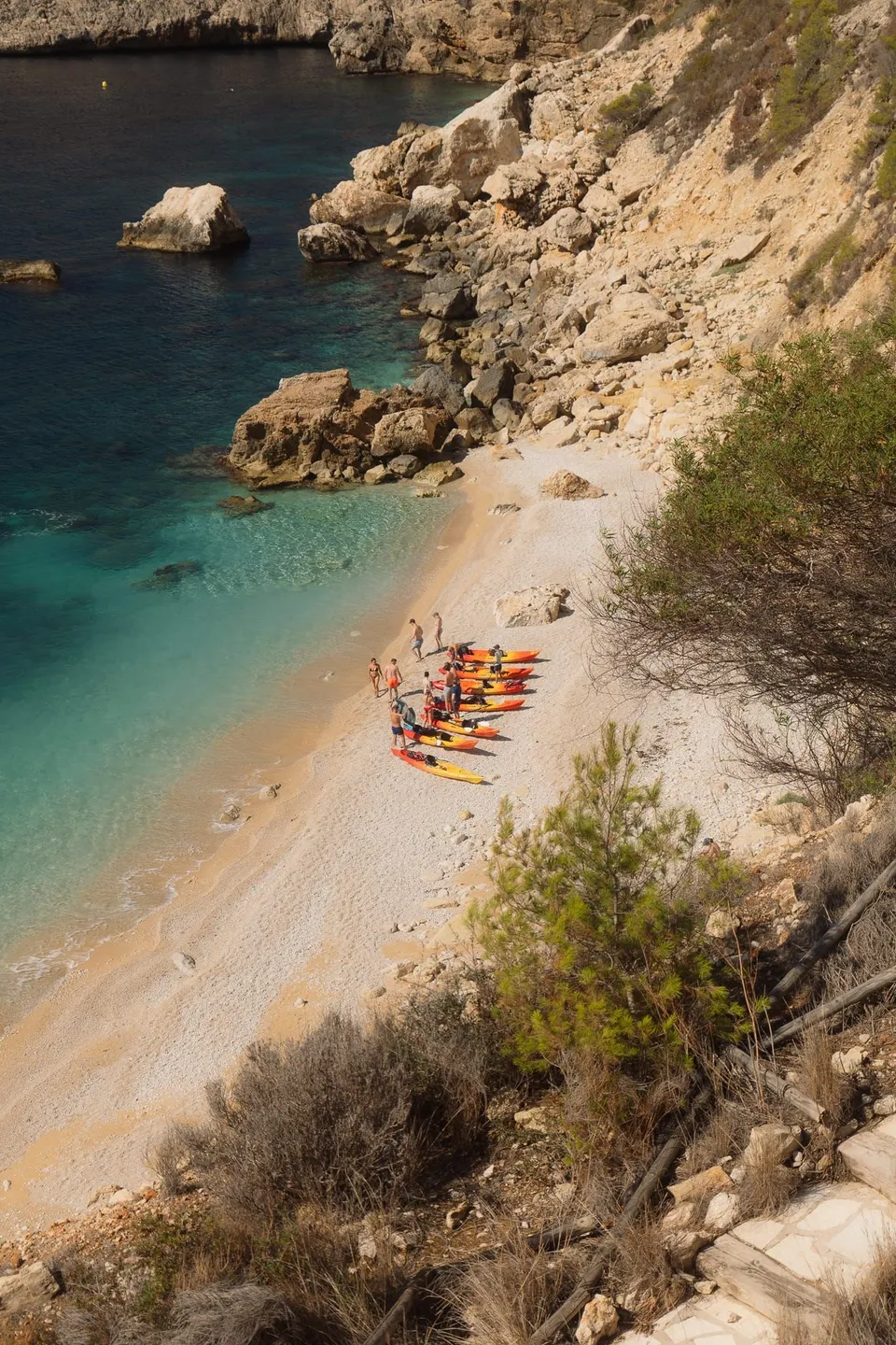 Kayaks beneath the natural arches of the Cova dels Arcs at Cala Moraig