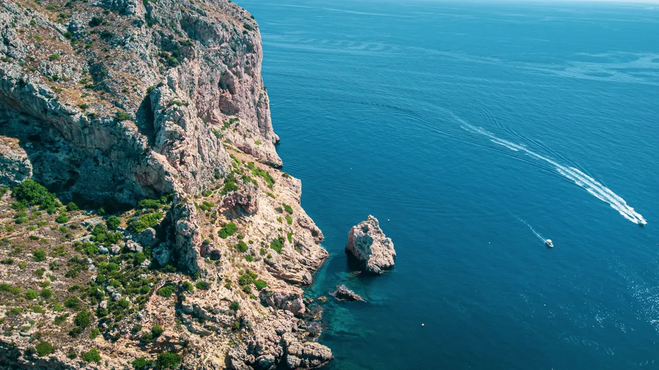 Kayaks beneath the natural arches of the Cova dels Arcs at Cala Moraig